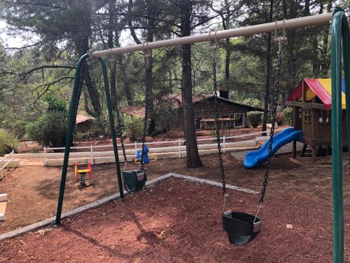 a swing set in a park with a playground at Monteverde in Mazamitla