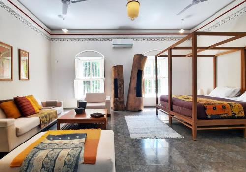 a living room with a bed and a couch at Saratha Vilas Chettinad in Kānādukāttān