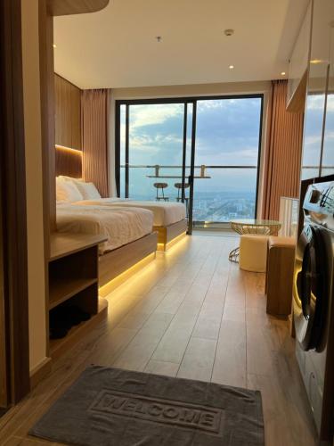 a hotel room with a bed and a large window at Apec Mandala Phú Yên Hương Giang Condotel in Liên Trì (3)