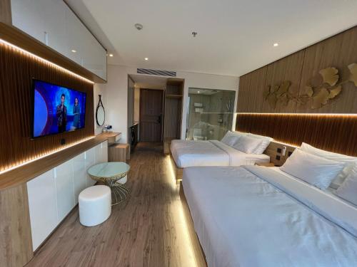 a hotel room with two beds and a flat screen tv at Apec Mandala Phú Yên Hương Giang Condotel in Liên Trì (3)
