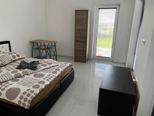 um quarto com uma cama, uma mesa e uma janela em Apartmány Dimitra 2 em Štúrovo