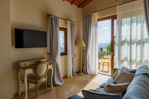 a living room with a blue couch and a tv and a window at Antichi Casali di Charme in Orvieto