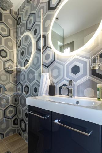 a bathroom with a sink and a mirror at GAIA MAISONETTES in Nea Kallikrateia