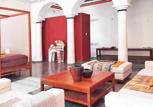 a living room with white columns and a table at Saratha Vilas Chettinad in Kānādukāttān