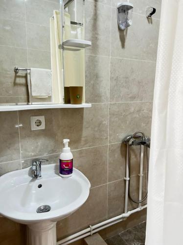 y baño con lavabo blanco y ducha. en Meiman House close to Asia Mall en Bishkek