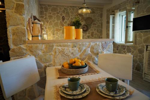 a table with two chairs and a bowl of oranges at TheHouse1905 in Parga