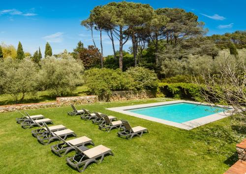a group of lounge chairs and a swimming pool at Hotel Albergo Villa Marta in Lucca