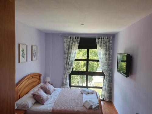 Schlafzimmer mit einem Bett vor einem Fenster in der Unterkunft VistaMar beautiful apartment with amazing sea view Pineda de Mar in Pineda de Mar