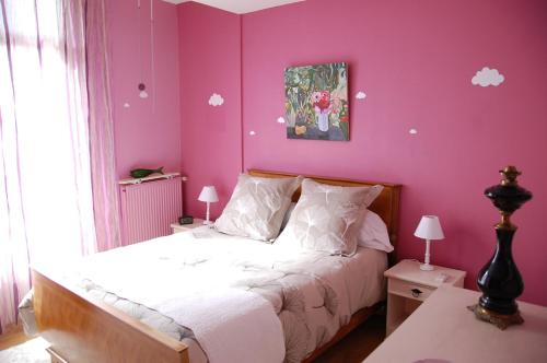 een slaapkamer met roze muren en een bed met witte lakens bij Appartement LA VIE EN ROSE in Périgueux