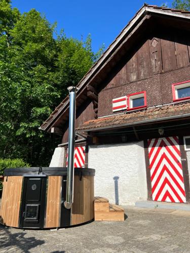 a building with a barn with red and white stripes at Romantic private superior Swiss Chalet with Hottub in Lungern
