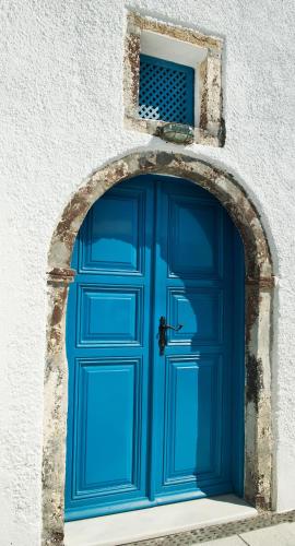 a blue door in a building with a window at Nikos Villas in Oia