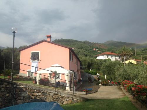 una casa rosa en una colina con una pared de piedra en Villa Giovanna Apt. B, en Sestri Levante