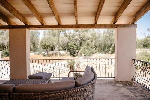 a patio with a couch and chairs on a deck at Finca Gomera - Agroturismo Hotel in Cala Pi