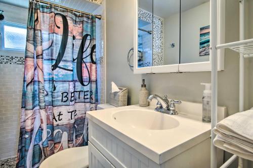 a bathroom with a sink and a shower curtain at Wareham Cottage with Deck, Walk to Swifts Beach in Wareham