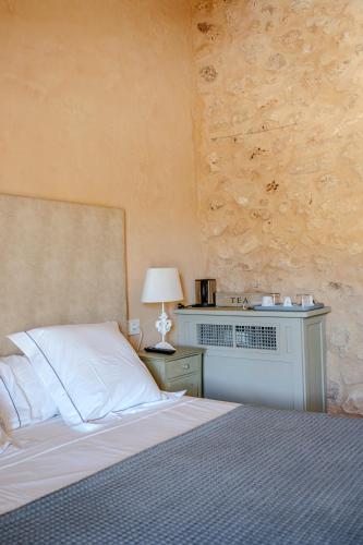 a bedroom with a bed and a table with a lamp at Finca Gomera - Agroturismo Hotel in Cala Pi