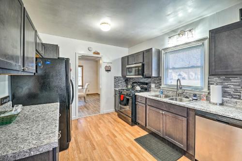 a kitchen with stainless steel appliances and wooden cabinets at Cozy Retreat with Yard about 2 Mi to Lake Michigan! in Muskegon