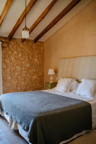 a bedroom with a bed and a stone wall at Finca Gomera - Agroturismo Hotel in Cala Pi