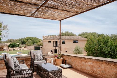 a patio with chairs and a table on a brick wall at Finca Gomera - Agroturismo Hotel in Cala Pi