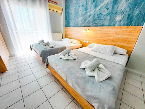 Dos camas en una habitación de hotel con toallas. en Rooms Anastasia Paralia en Kateríni