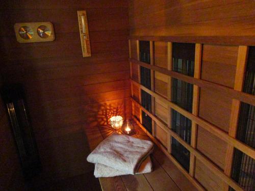 een kleine kamer met een bank en een boekenplank bij Secret Wellness Puur Natuur in Holten