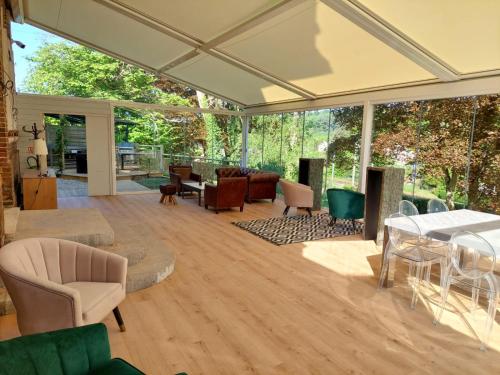 a conservatory with a table and chairs at Le Clos des Lodges in Bernay