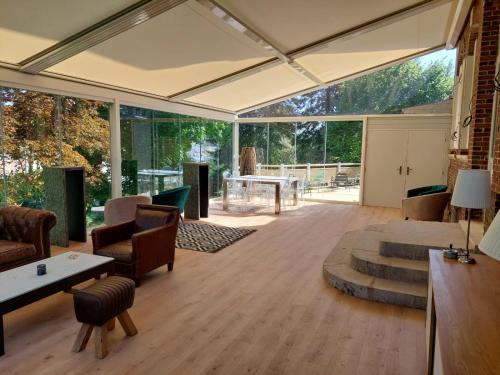 een open woonkamer met een grote glazen wand bij Le Clos des Lodges in Bernay