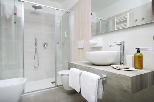 ein Bad mit einem Waschbecken, einem WC und einer Dusche in der Unterkunft Hotel Villa Smeralda in Malcesine