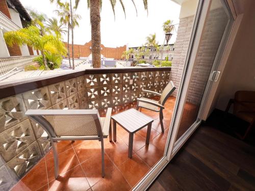 a balcony with two chairs and a table at San Nicolas Hotel Casino in Ensenada