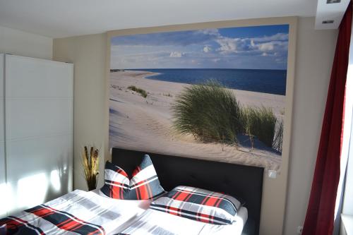 a bedroom with a painting of a beach at Apartment mit Meeresblick in Binz