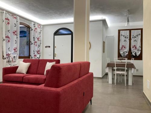 sala de estar con sofá rojo y mesa en La Tillanzia, en Dolceacqua