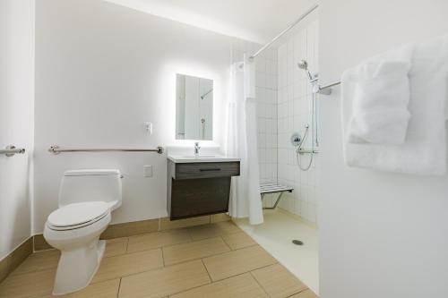 a white bathroom with a toilet and a sink at Hotel Bethany Beach in Bethany Beach