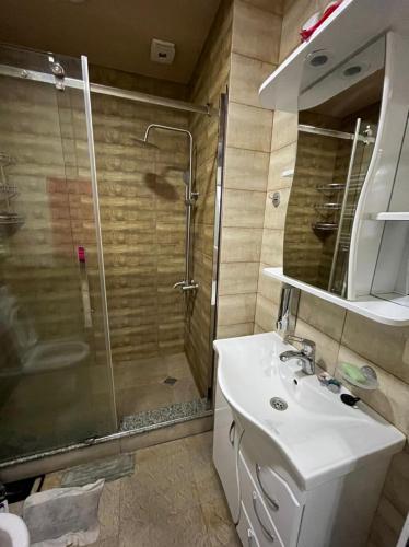a bathroom with a sink and a shower at Apartament DeLux Sea View in Batumi