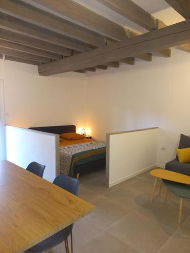 a bedroom with a bed and a table and chairs at Les Eygletières in Bourriot-Bergonce