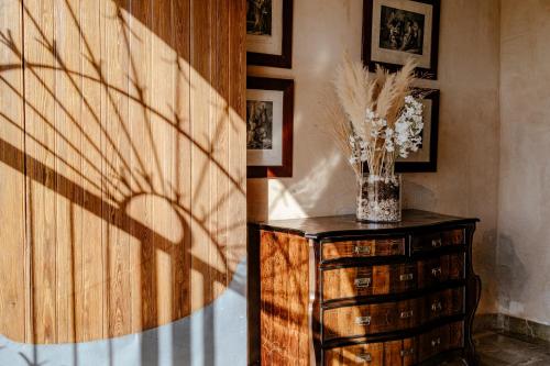 a vase of flowers on a dresser in a room at Finca Gomera - Agroturismo Hotel in Cala Pi