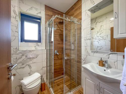 a bathroom with a shower and a toilet and a sink at MaNora in Ulcinj