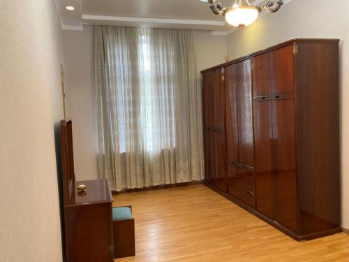 a room with a large wooden cabinet and a large window at House NAG in Kutaisi
