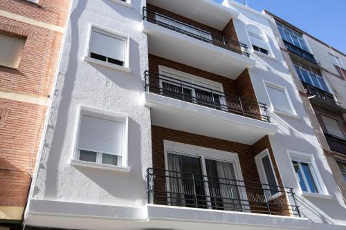 a white building with balconies on the side of it at Vivienda con Fines turísticos "San Bartolomé" in Andújar