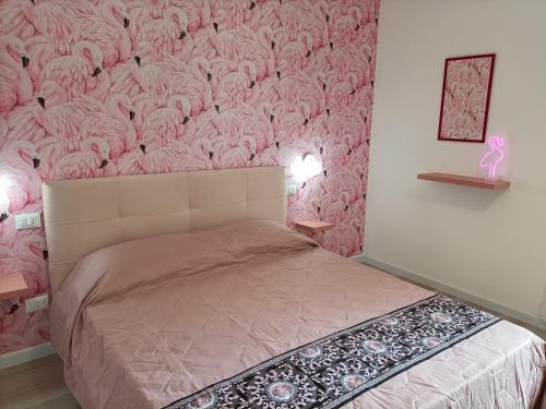 a bedroom with a pink wall with a bed at TINTARELLA in Trapani