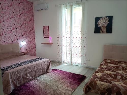 a bedroom with a bed and a window and a rug at TINTARELLA in Trapani