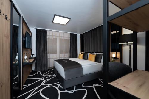 Pokój hotelowy z łóżkiem i biurkiem w obiekcie Hotel Unique Pearl w Dortmundzie