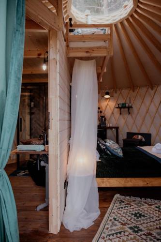 a wedding dress hanging from the wall of a room at Jurty z widokiem, prywatna balia- DZIKOLAS GLAMPING in Krasnobród
