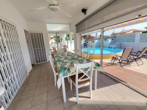un balcone con tavolo, sedie e piscina di Torredembarra cosy, well equipped house, 5 min. from the beach a Torredembarra