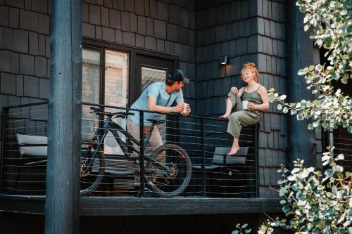 a man and a woman on a balcony with a bike at Gravity Haus Jackson Hole in Teton Village