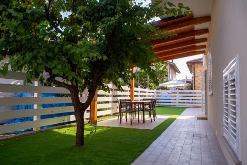 a patio with a tree and a table and chairs at Aria di Sale in Martinsicuro