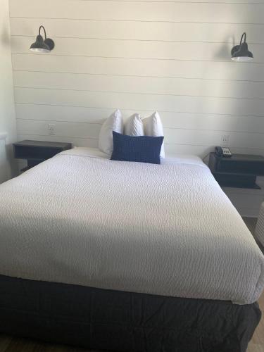 a bedroom with a white bed with a blue pillow at The ShoreHouse in Ocean City