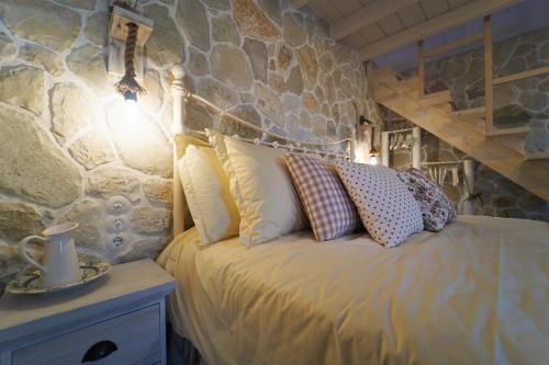 a bedroom with a bed with a stone wall at TheHouse1905 in Parga