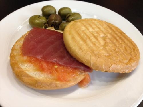 a plate of food with a doughnut and a pickle at Torreluz Centro in Almería