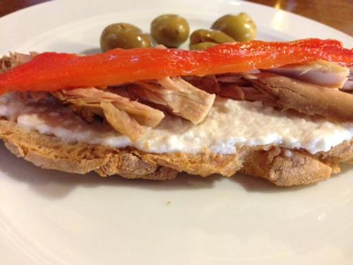 a sandwich with meat and vegetables on a white plate at Torreluz Centro in Almería