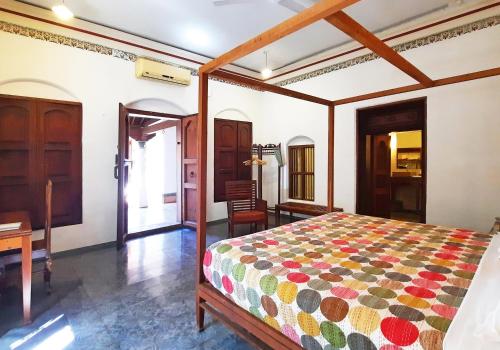 a bedroom with a bed and a desk at Saratha Vilas Chettinad in Kānādukāttān