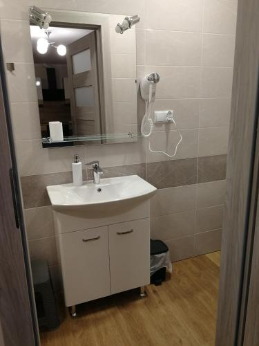 a bathroom with a sink and a mirror at Pokoje Gościnne Finezja in Zamość